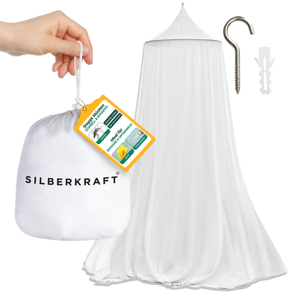 Eén hand houdt de verpakkingszak van het Silberkraft-klamboe vast. Op de achtergrond zie je het gespannen net, een plug en een muurhaak.