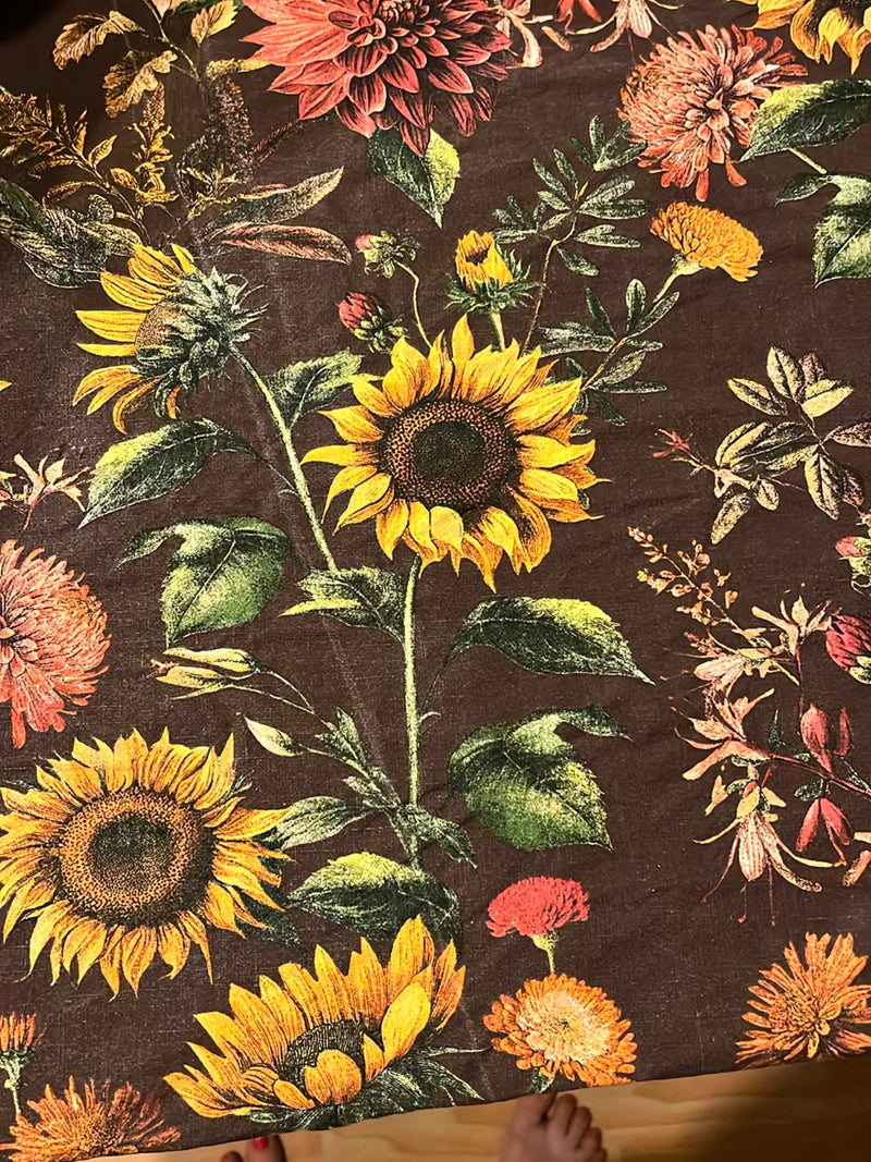 Het stofpatroon toont several gele zonnebloemen met donkere centra en groene bladeren. De illustratie toont verschillende bloeiwijzen tegen een bruine achter...