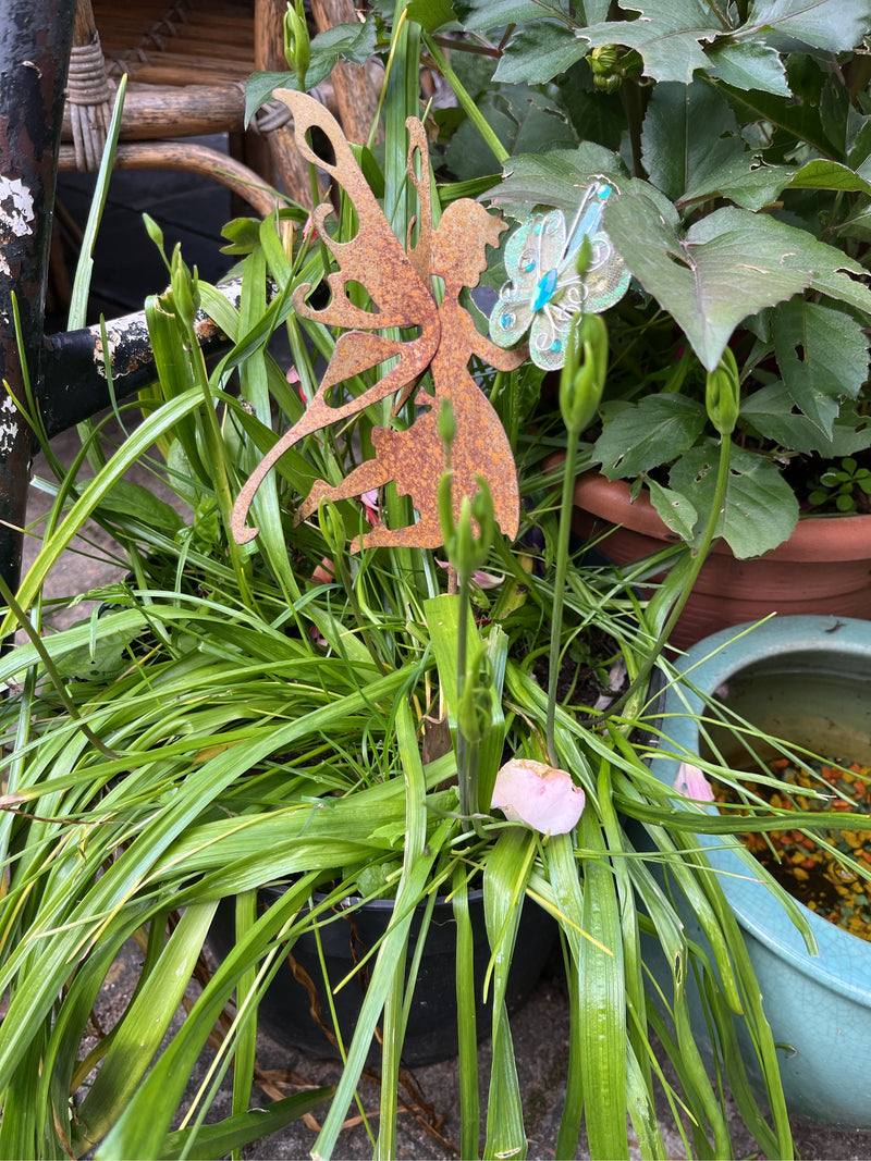 Groene bladeren en knoppen van dagsnoeren zijn zichtbaar in een bloempot. Er zijn ook decoratieve figuren in te zien.